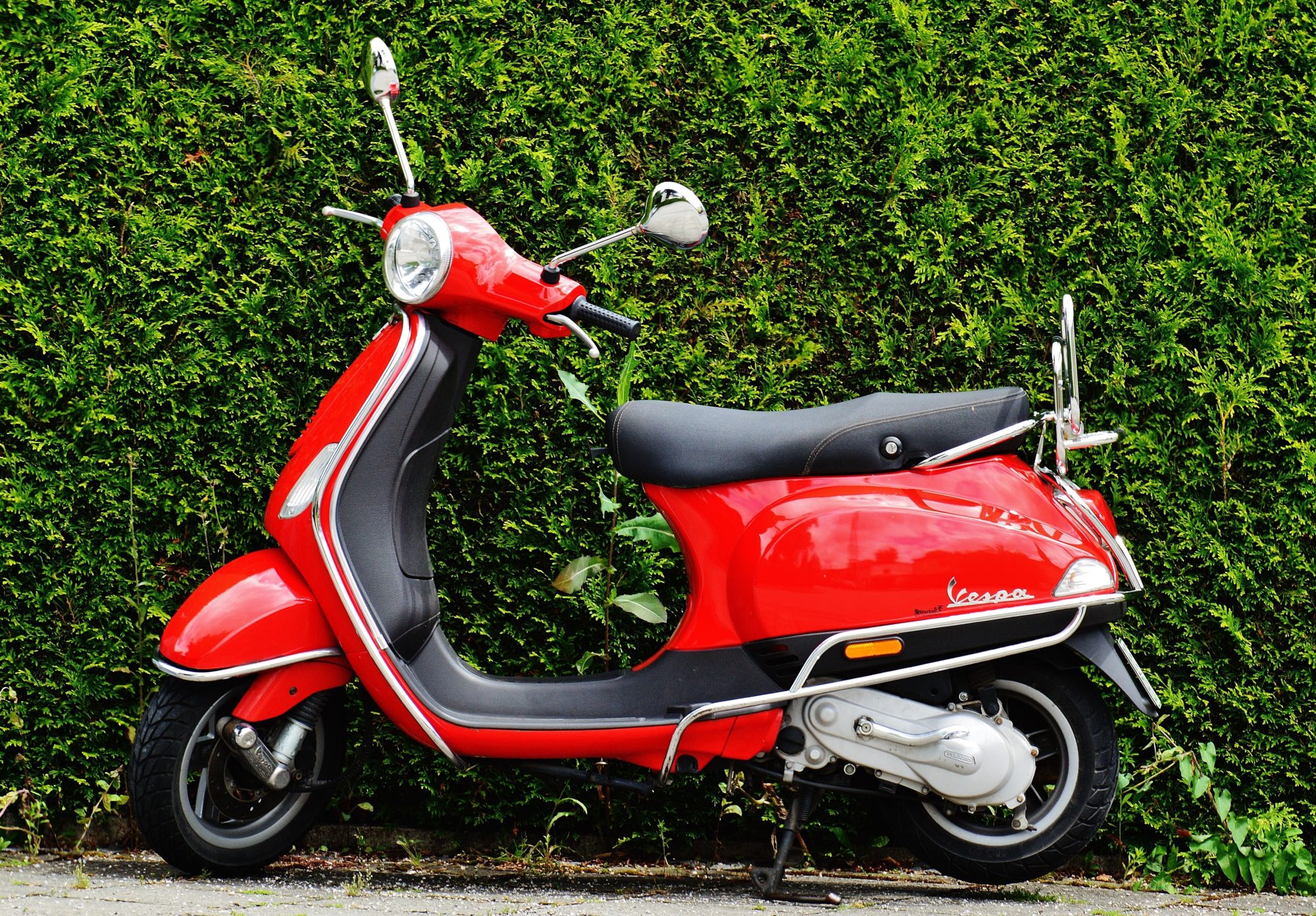 red-and-black-moped-scooter-beside-green-grass-159192